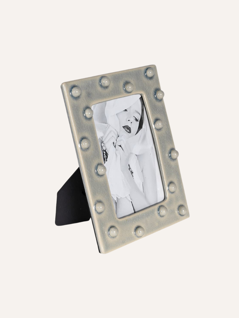 Decorative grey ceramic dotty photo frame with a vintage design on a white background