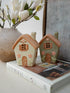 Two small ceramic houses on a book with a decorative background