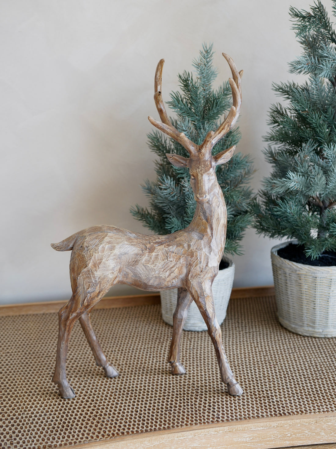 Decorative deer figure in a room with potted plants