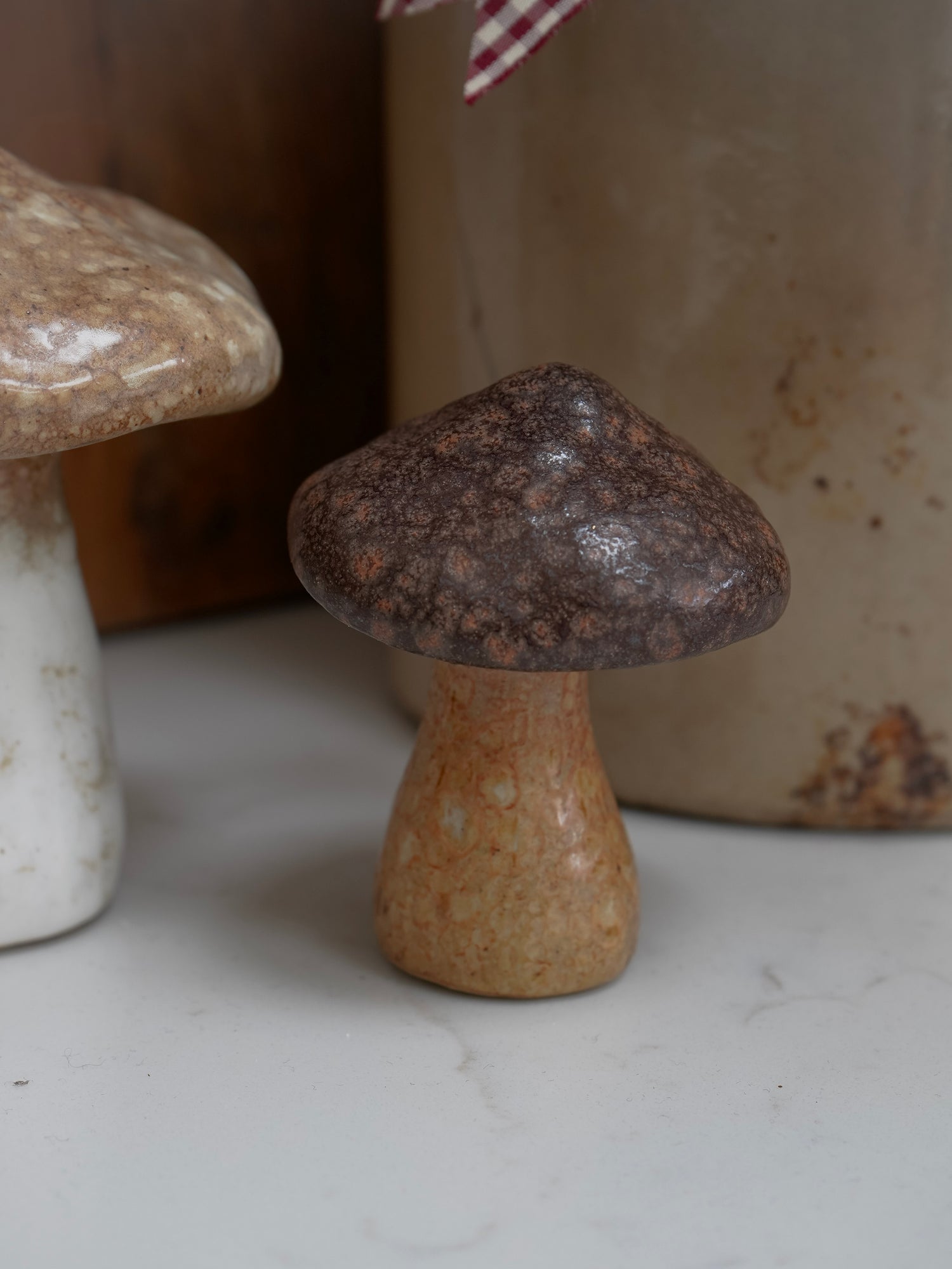 Ceramic mushroom on a white surface with a blurred background