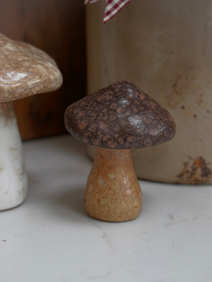 Ceramic mushroom on a white surface with a blurred background