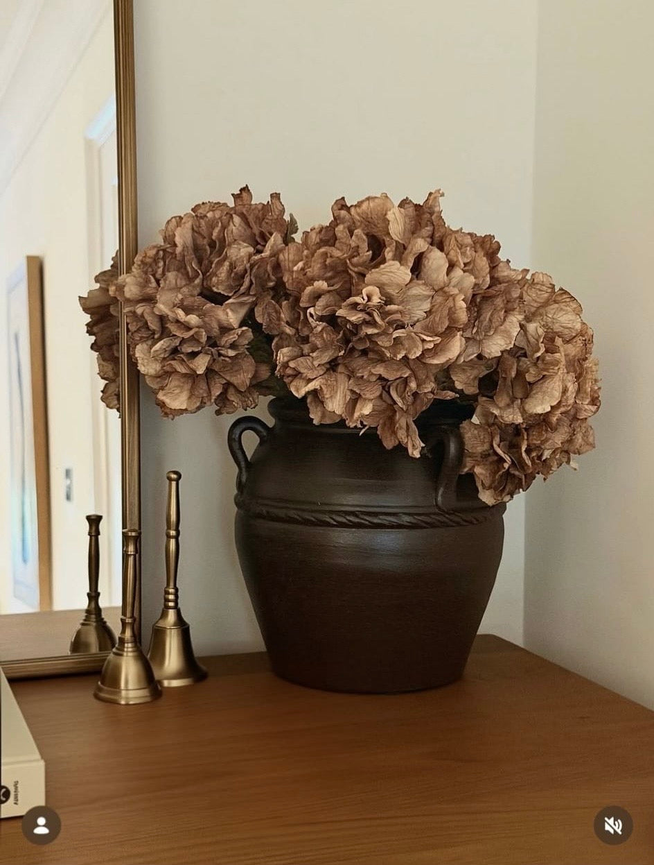Faux dried ruffle brown cappuccino hydrangeas in rustic brown vase with brass bells