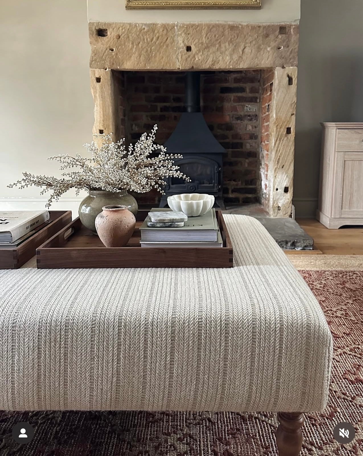Beige ottoman styled with faux soft cream heather stems