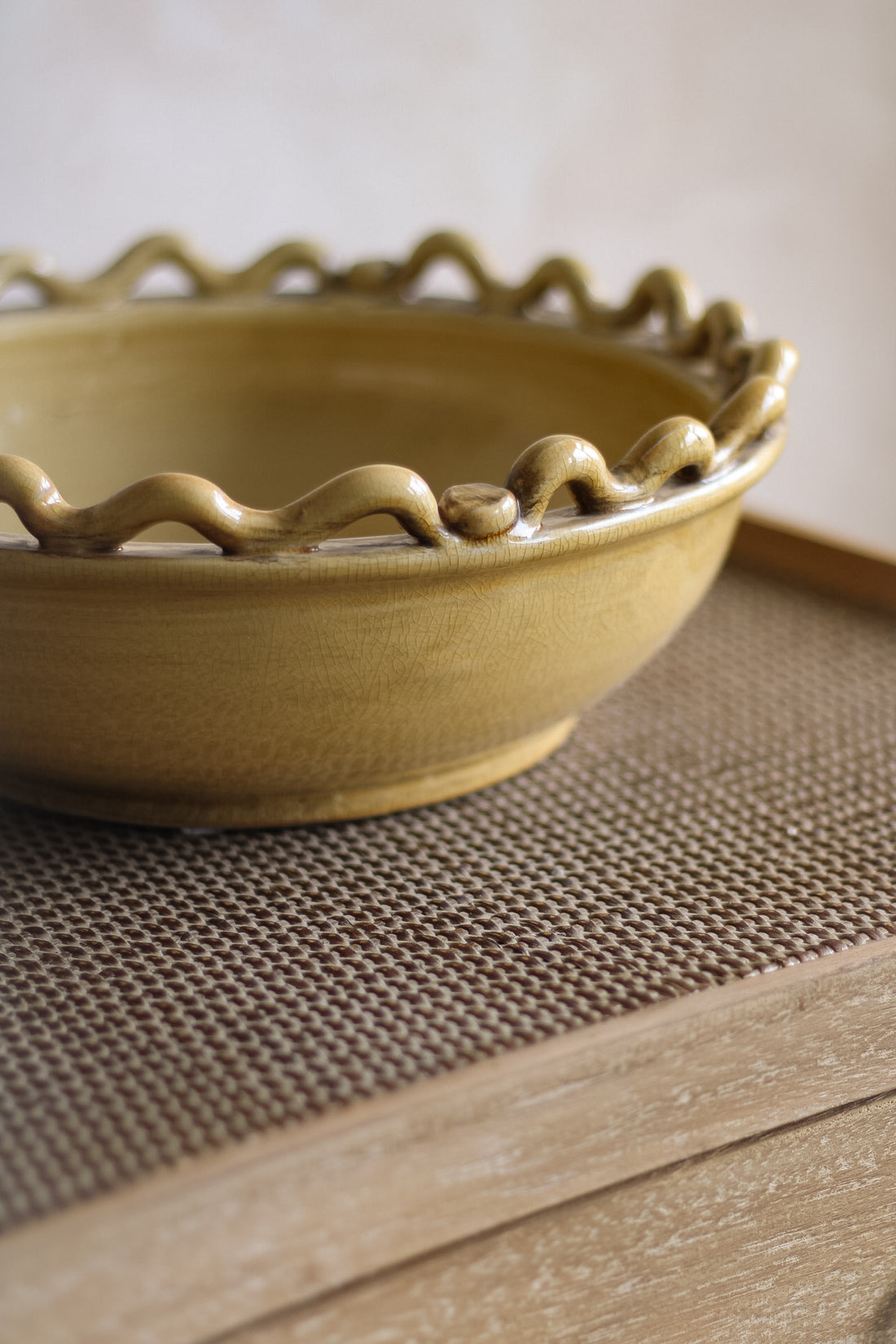 Ceramic bowl with wavy edge on a textured surface