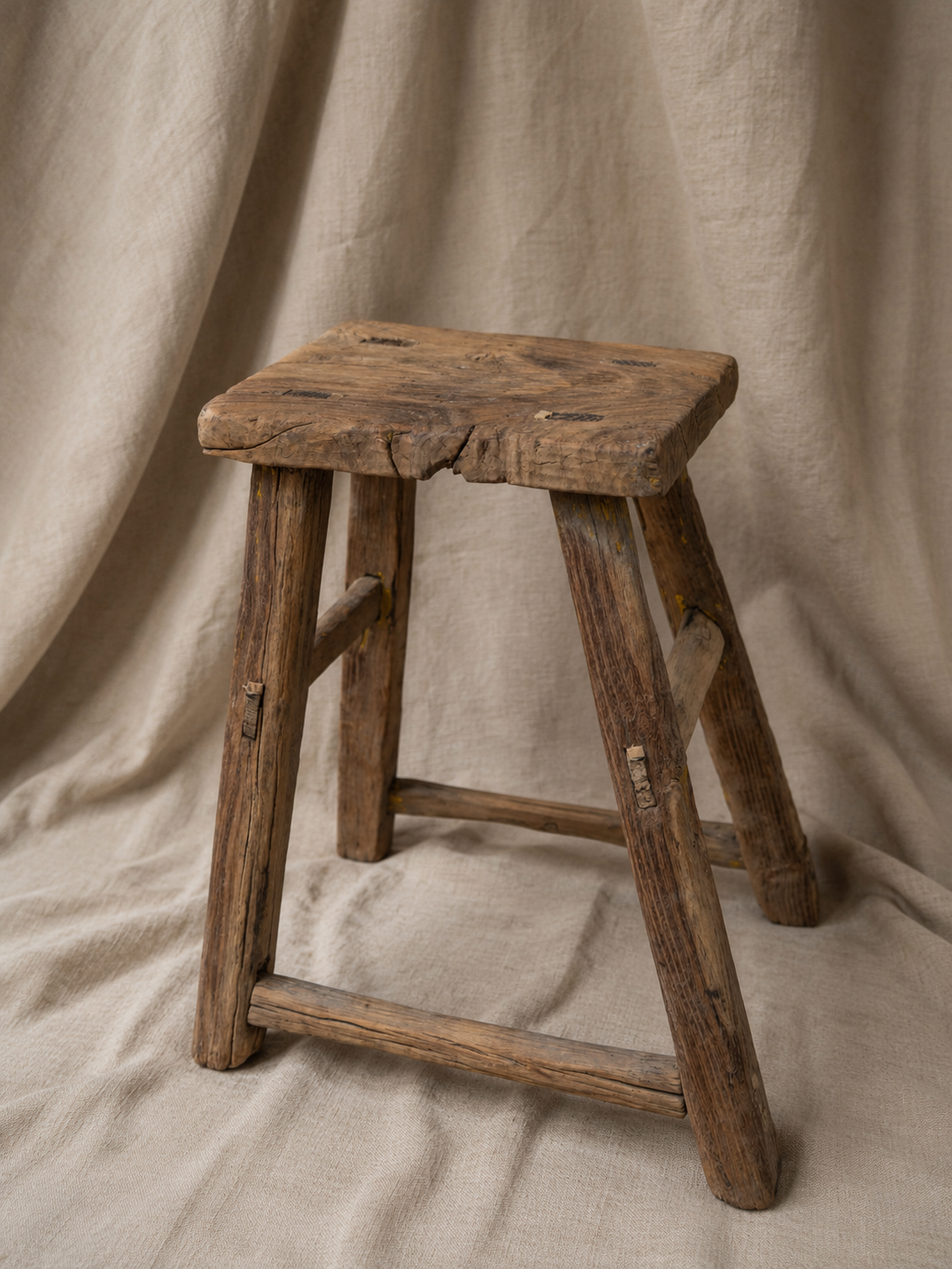 Wooden stool on a beige fabric background