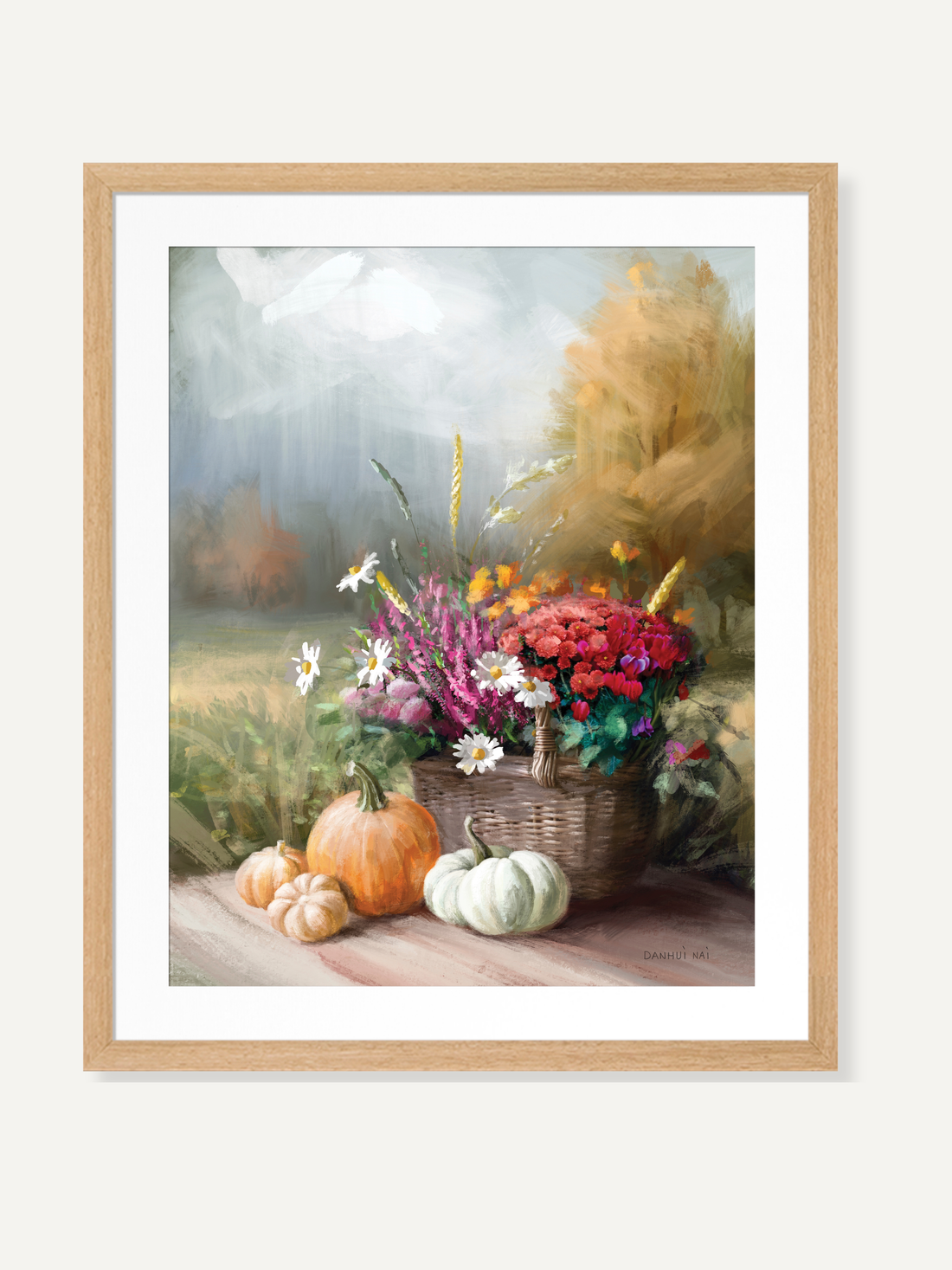 Framed wall art of a basket of flowers with pumpkins on a wooden surface.
