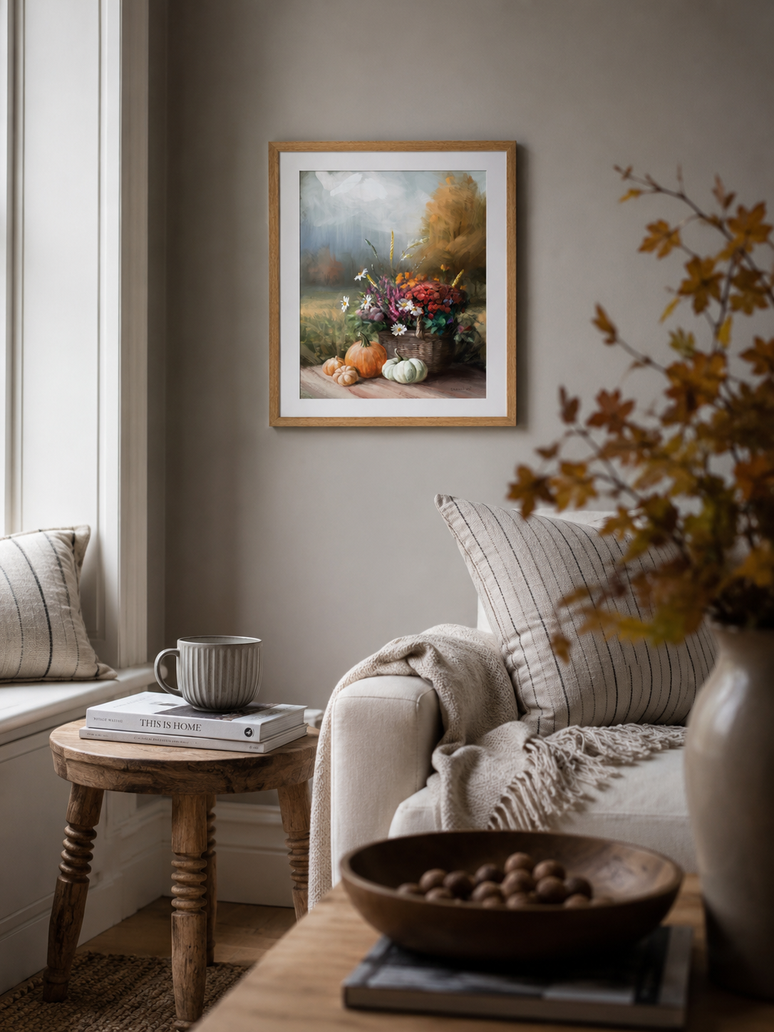 Cosy living room with a framed autumn inspired wall art, books, and decorative items.