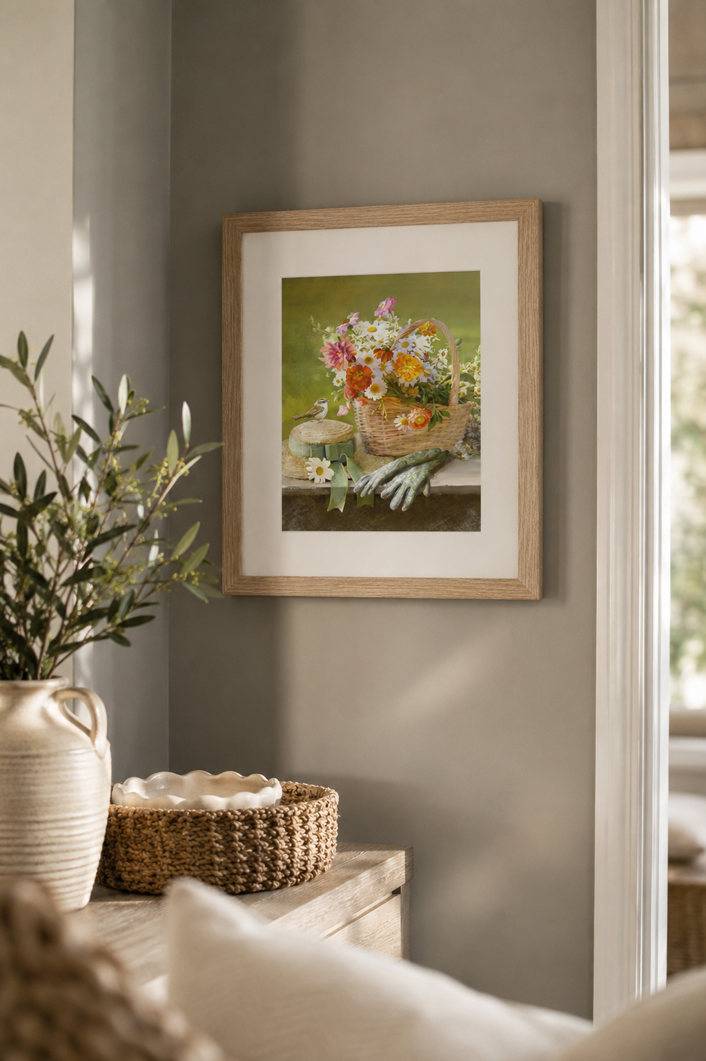 Framed artwork of a floral basket on a wall in a room with decor elements.