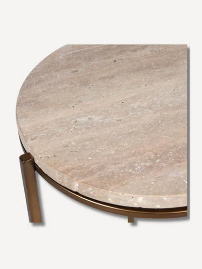 Round travertine table with bronze base on a white background