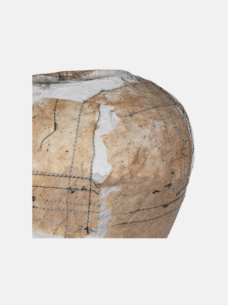 Close-up of a textured surface vase with patterns and cracks on a white background