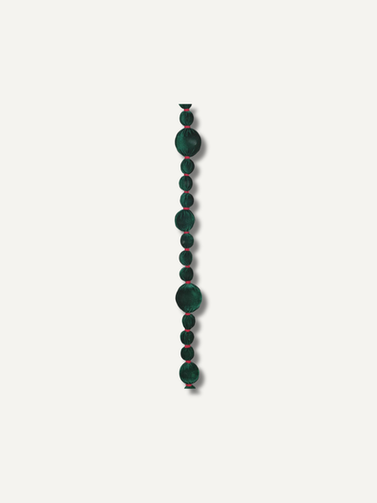 A single strand of dark green bobble beads garland with subtle red edges, arranged vertically against a solid off-white background.