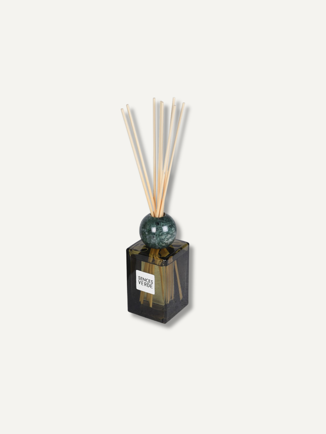 A reed diffuser with a dark green glass bottle, a green marble sphere, and natural reed sticks, shown on a light beige background.