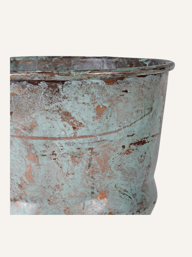 Vintage-style metal planter with a patina finish on a white background