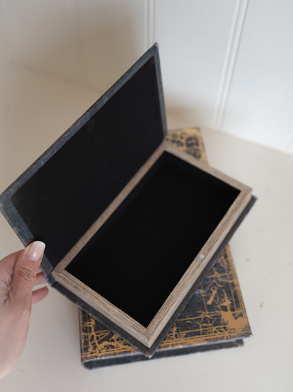 Open storage book box with gold design on a white surface