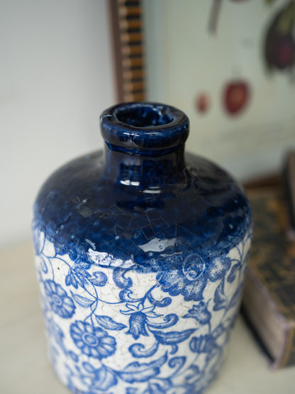 Blue and white ceramic vase with floral patterns on a blurred background
