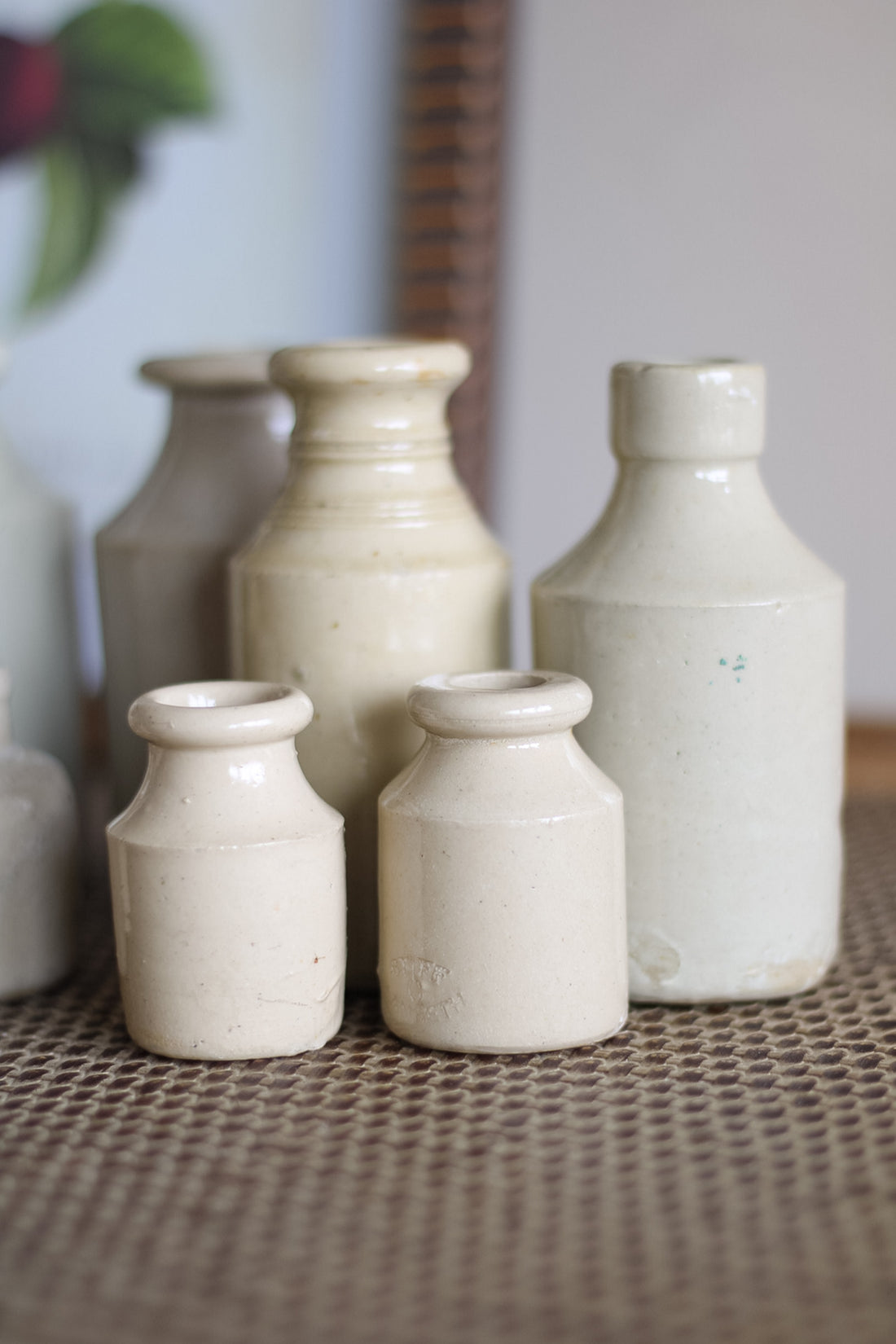 Set of ceramic bottles on a textured surface with a blurred background