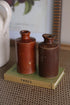 Two brown ceramic bottles on a green book titled &