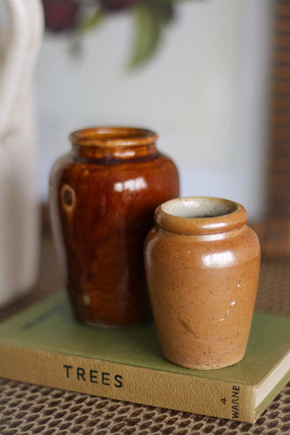 Two ceramic jars on a book titled &