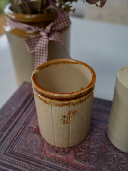Close-up of a ceramic pot with a textured surface on a patterned surface.
