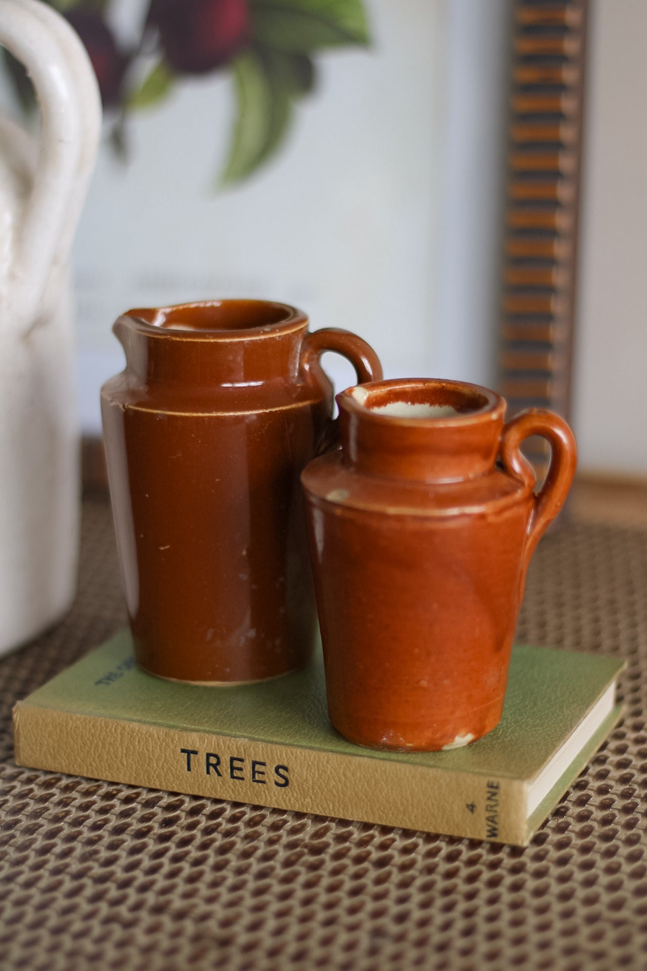 Two brown ceramic jugs on a book titled &