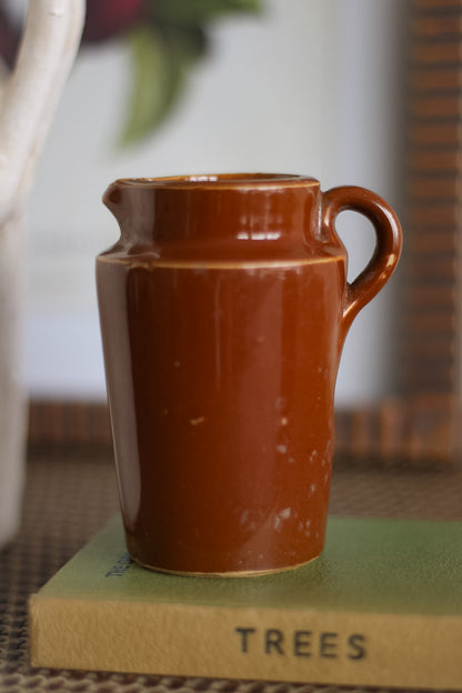 Brown ceramic vintage jug on a green book with &