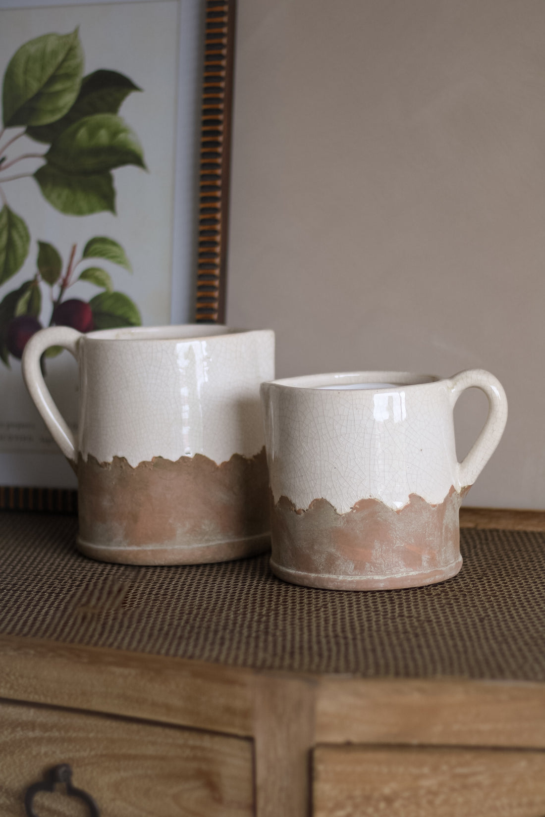 Two ceramic mugs with a gradient design on a wooden surface.
