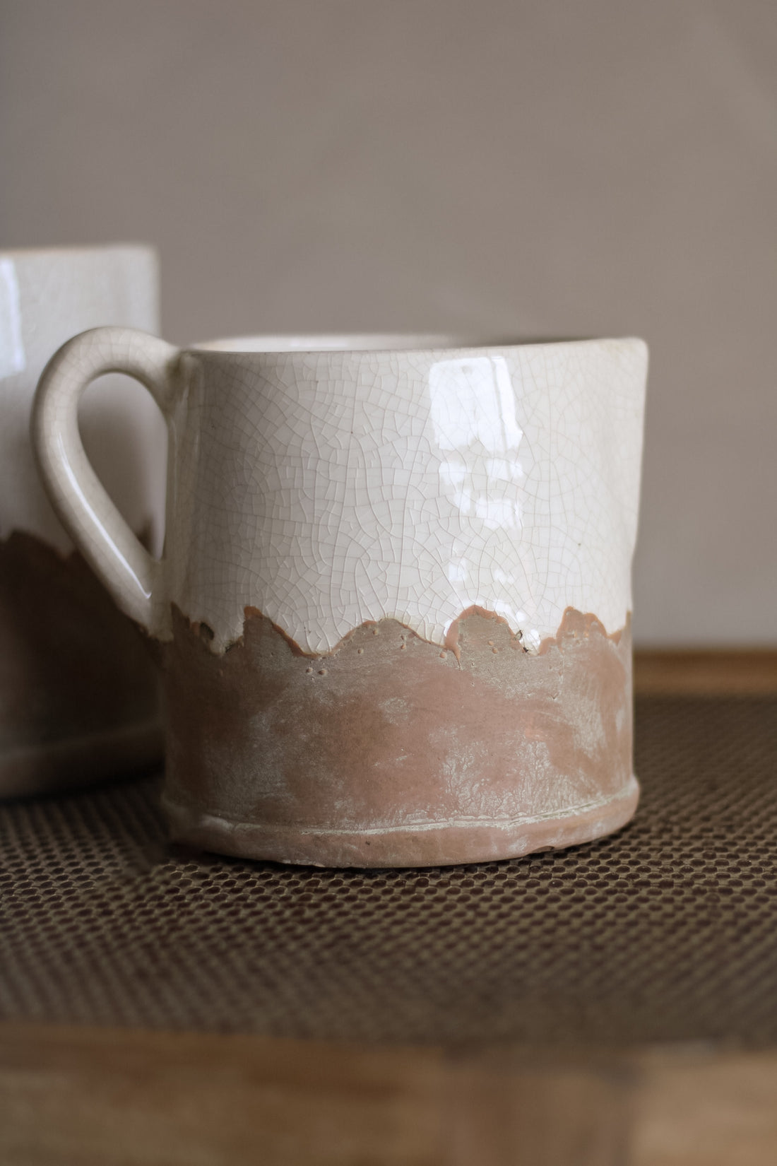White ceramic mug with brown base on a textured surface