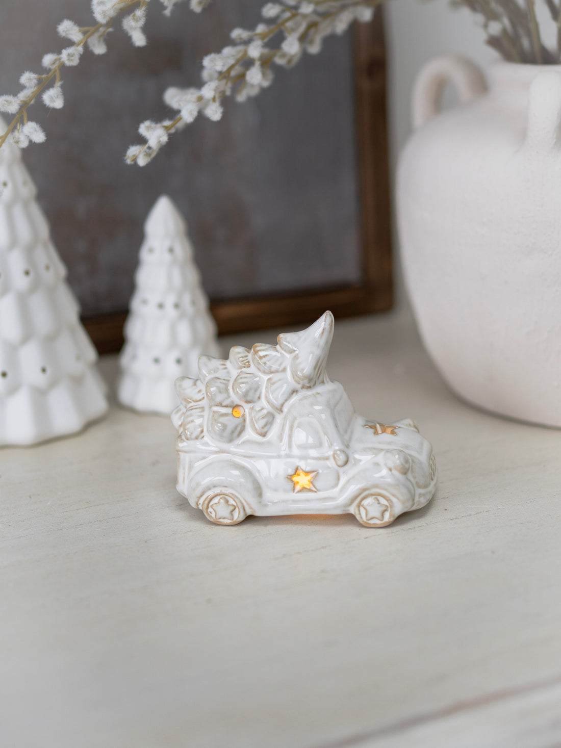 Decorative white ceramic cat figurine with a star on a neutral background