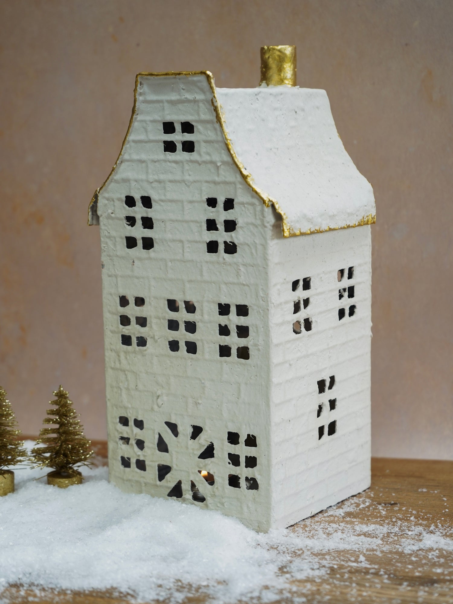 Decorative house-shaped lantern with a gold roof on a neutral background