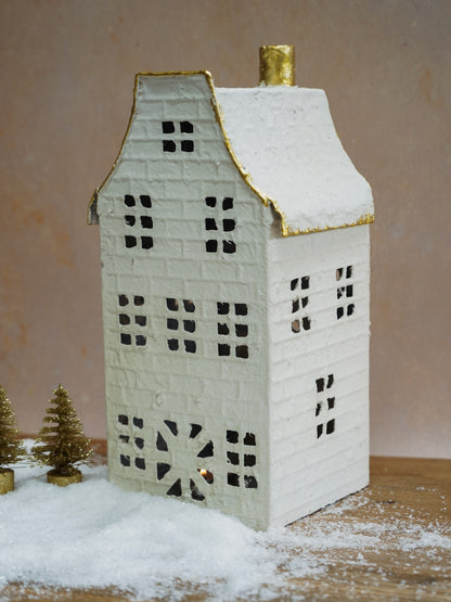 Decorative house-shaped lantern with a gold roof on a neutral background