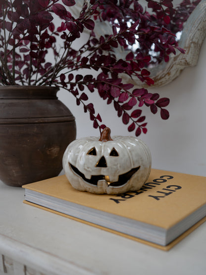 A small white ceramic jack-o&