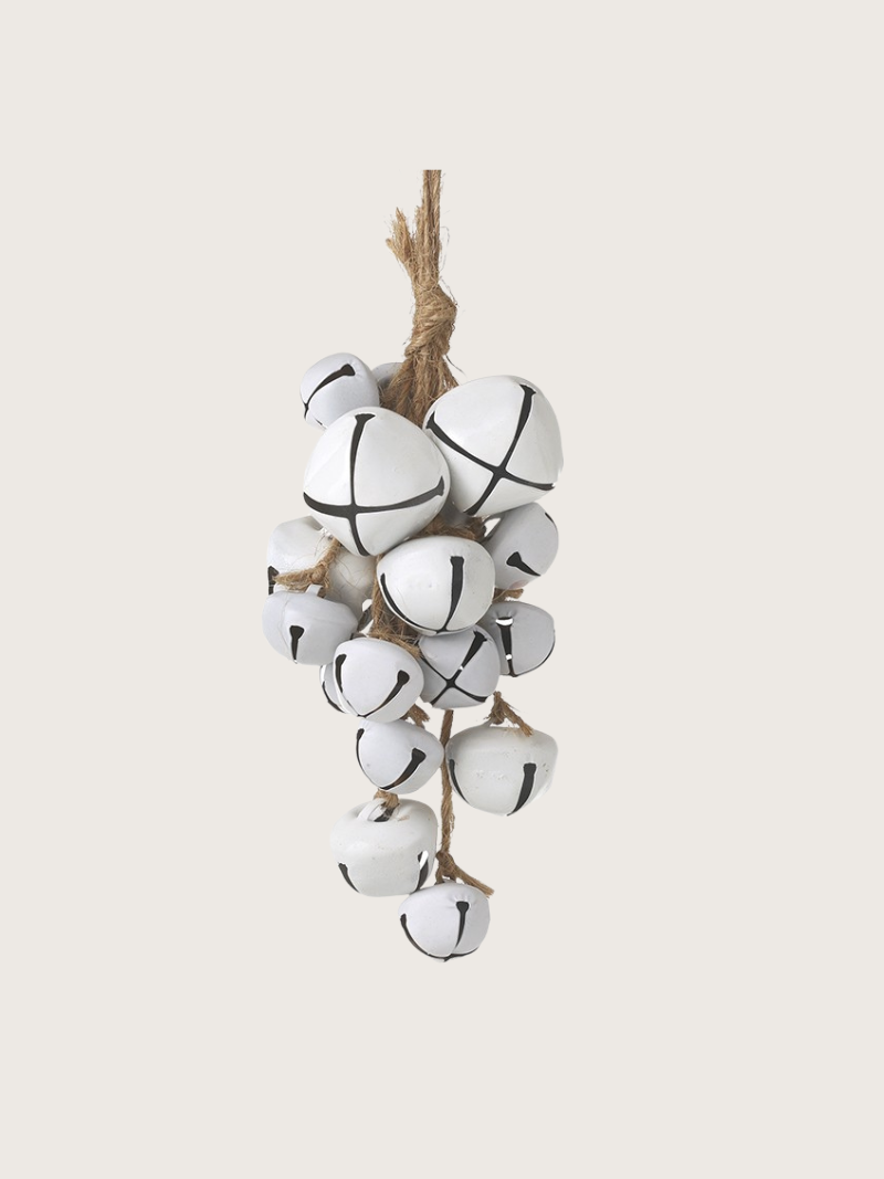 White ceramic bells on a string against a white background