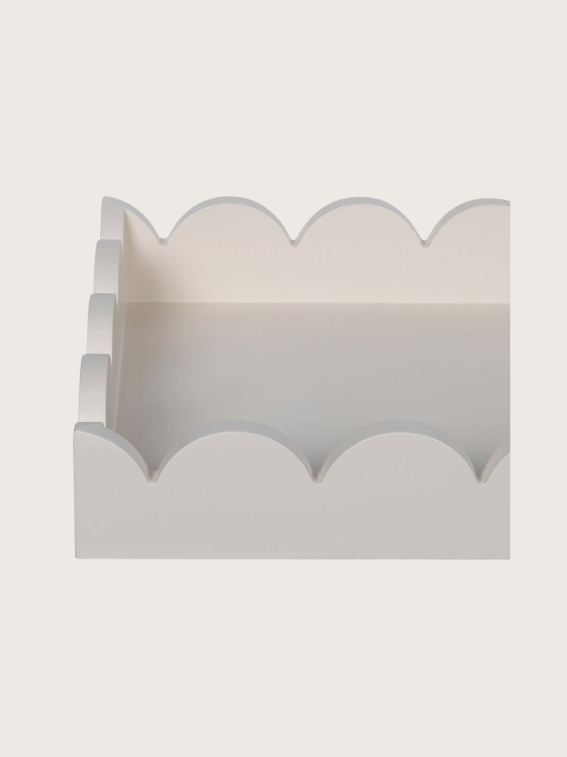 Decorative wooden tray with scalloped edge on a light gray background