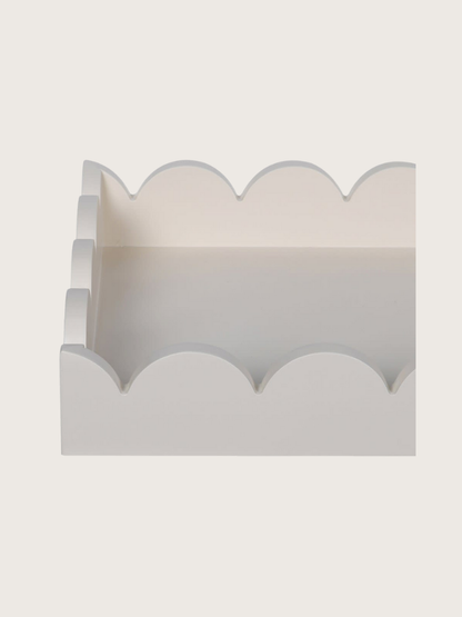 Decorative wooden tray with scalloped edge on a light gray background