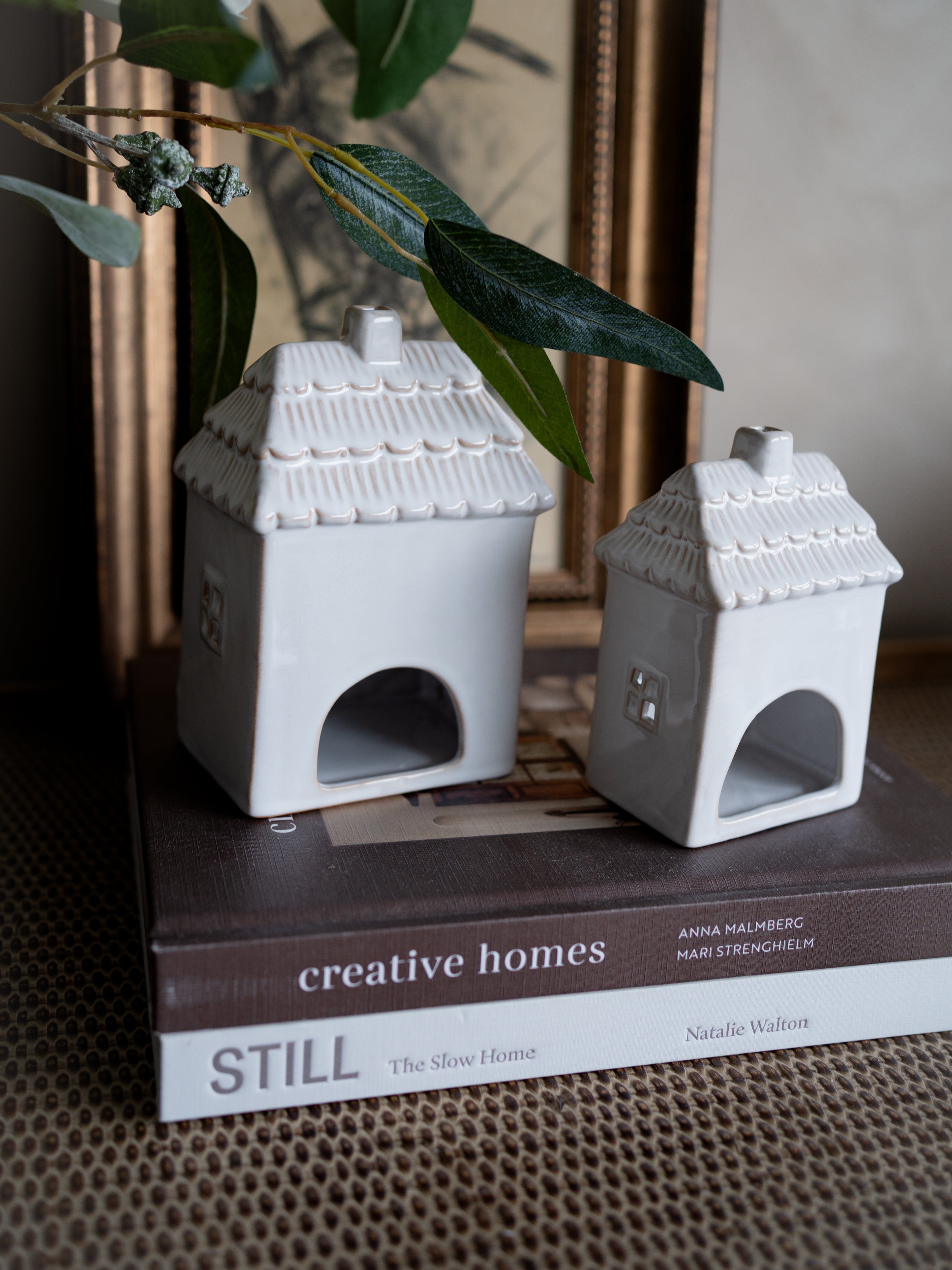 Two small white ceramic houses on a book titled &