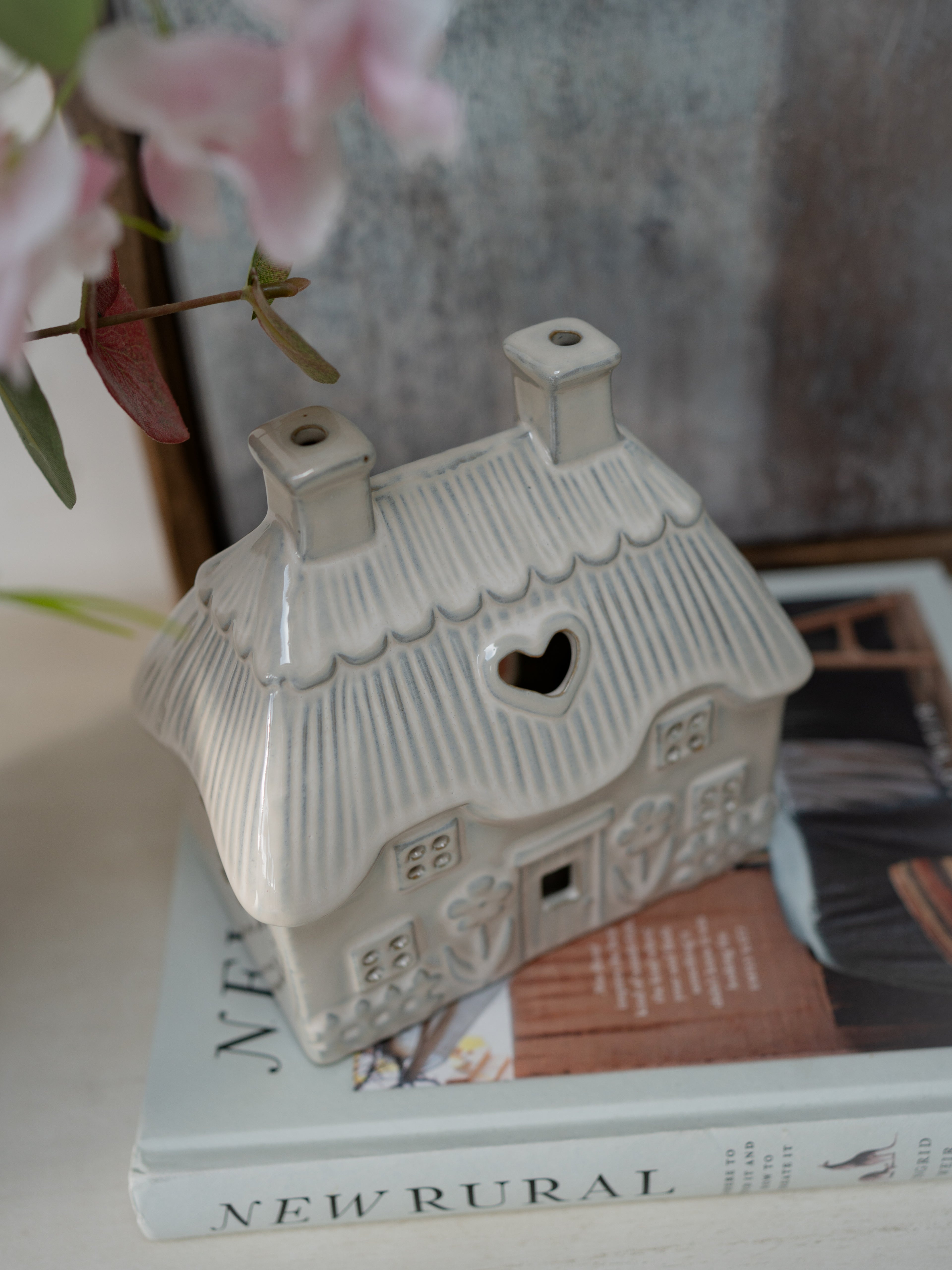 Decorative ceramic house on top of a book with a blurred background