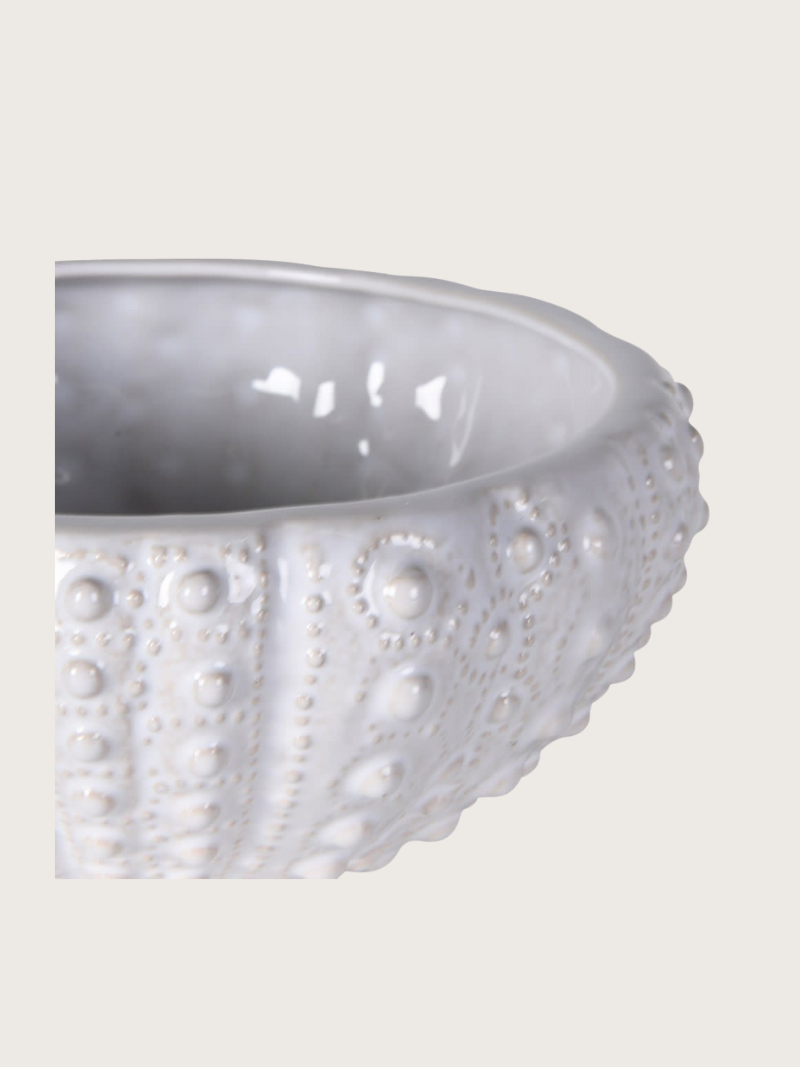 White ceramic bowl with textured surface on a light gray background