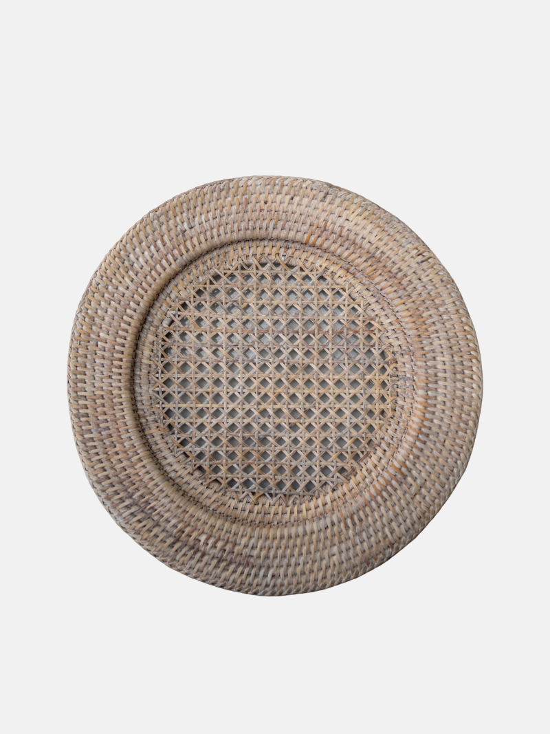Round woven placemat with a textured pattern on a light gray background