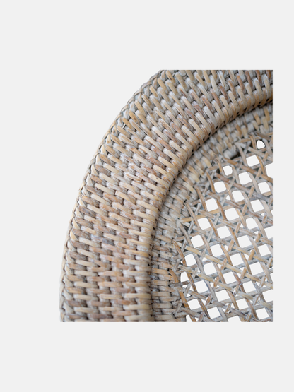 Close-up of a woven rattan charger plate on a white background