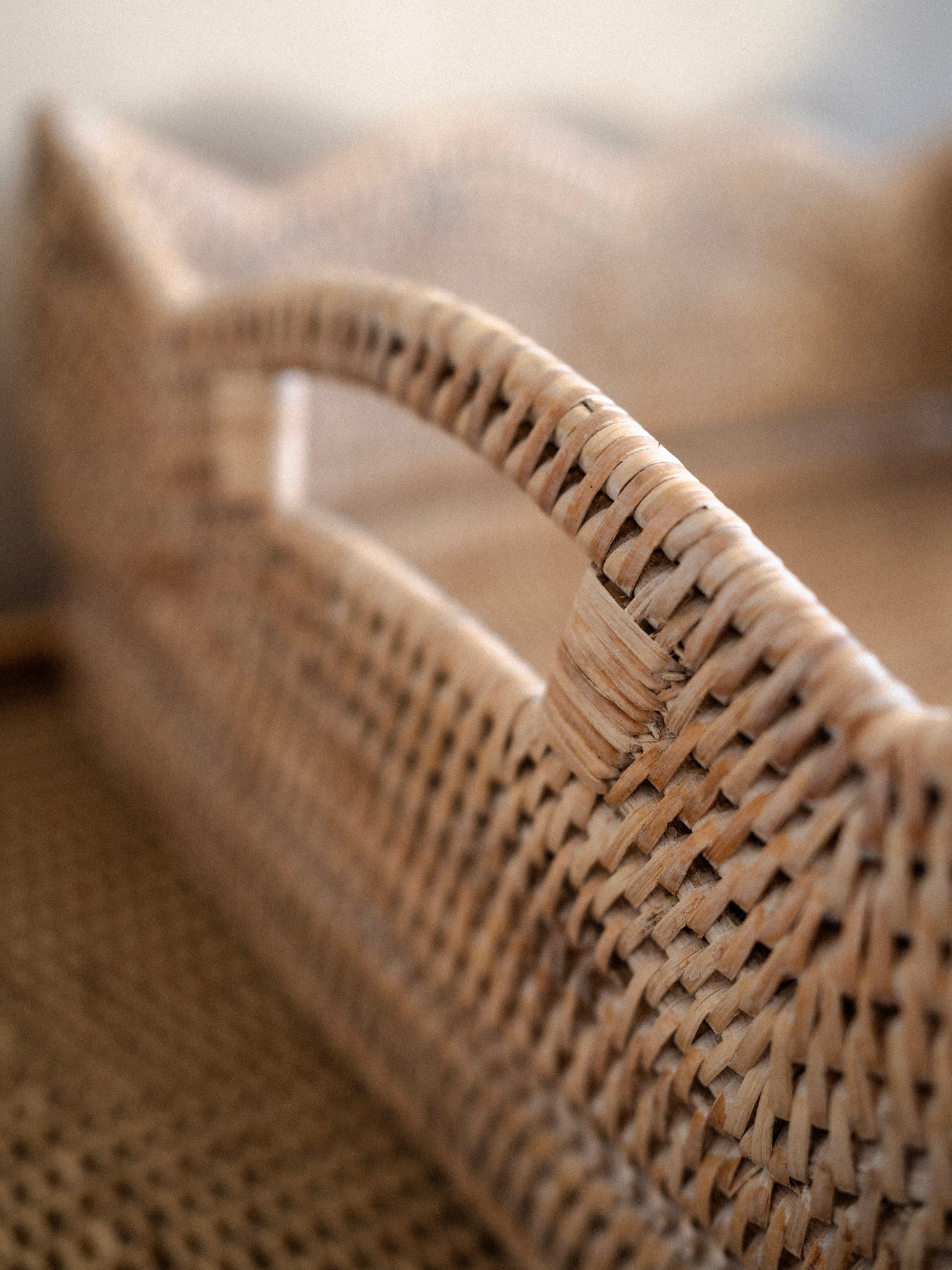 Close-up of a white washed woven rattan  basket tray with a blurred background