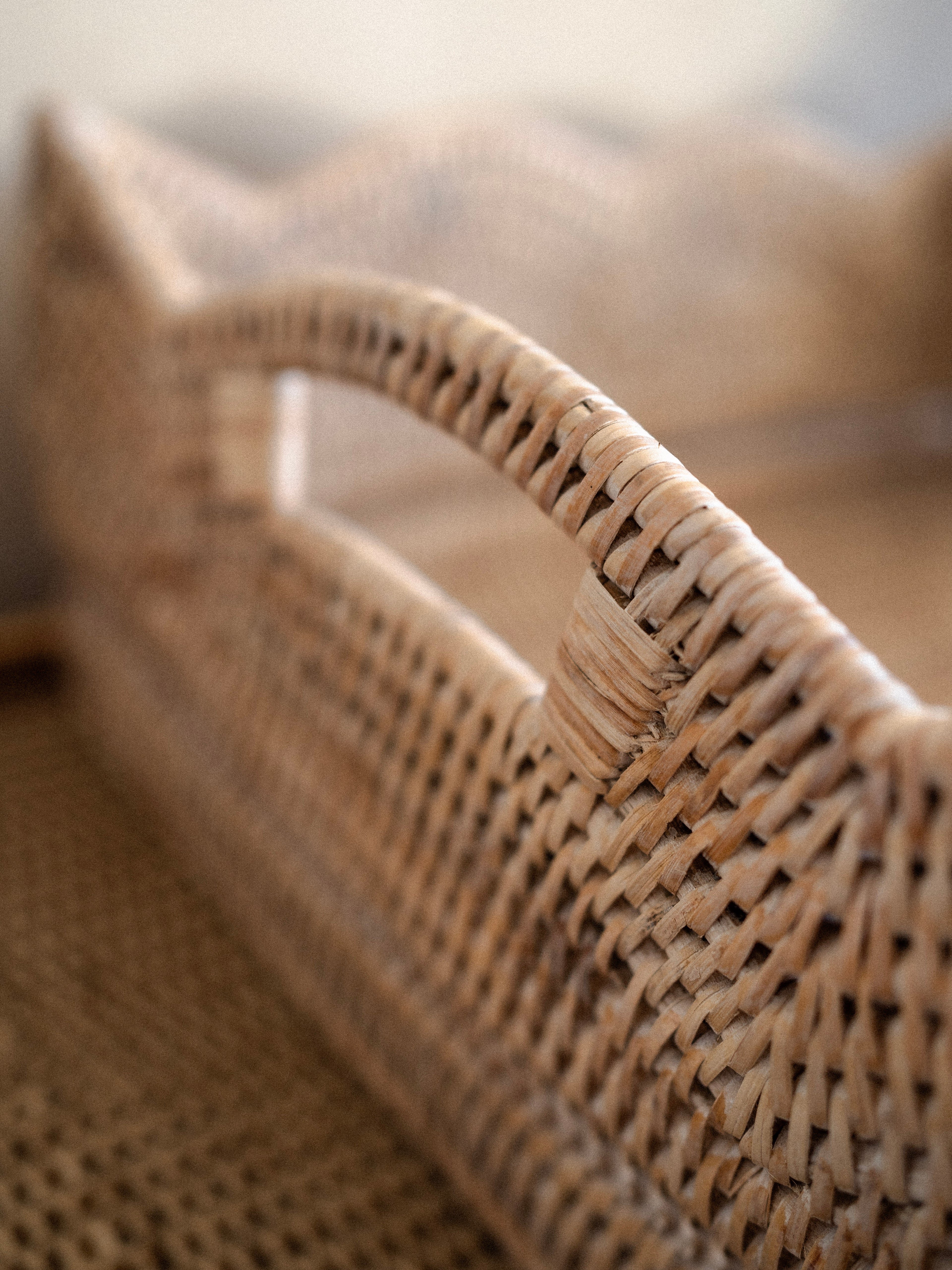 Close-up of a white washed woven rattan  basket tray with a blurred background