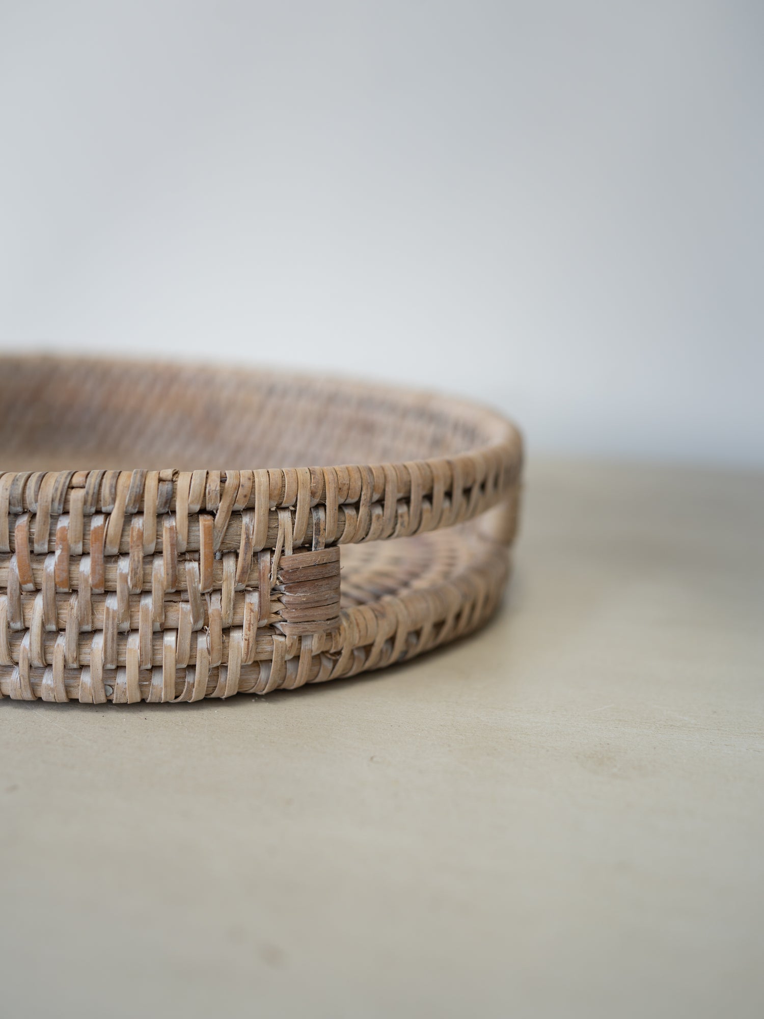 up close of cutout handle detail on white washed rattan tray