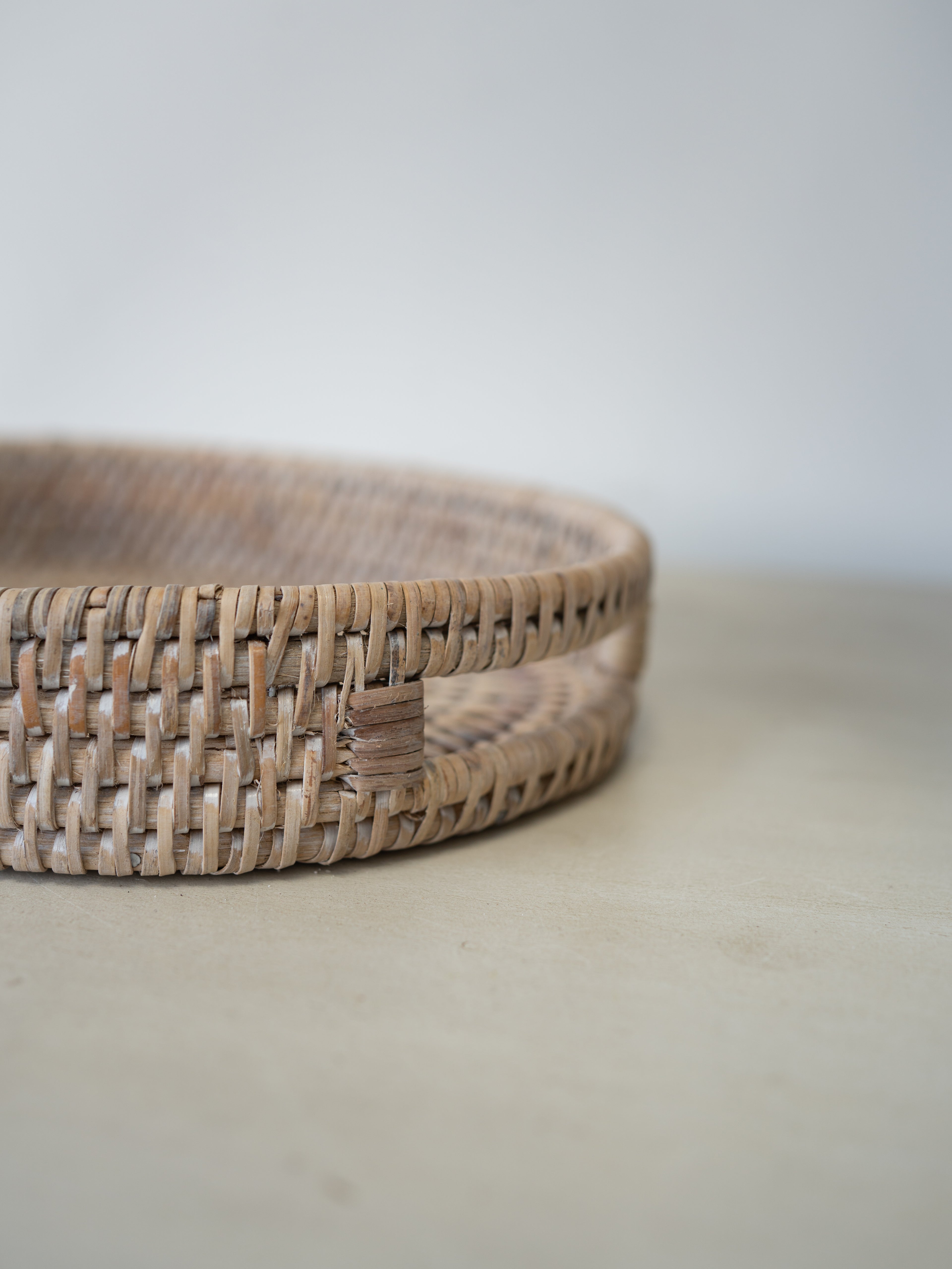 up close of cutout handle detail on white washed rattan tray