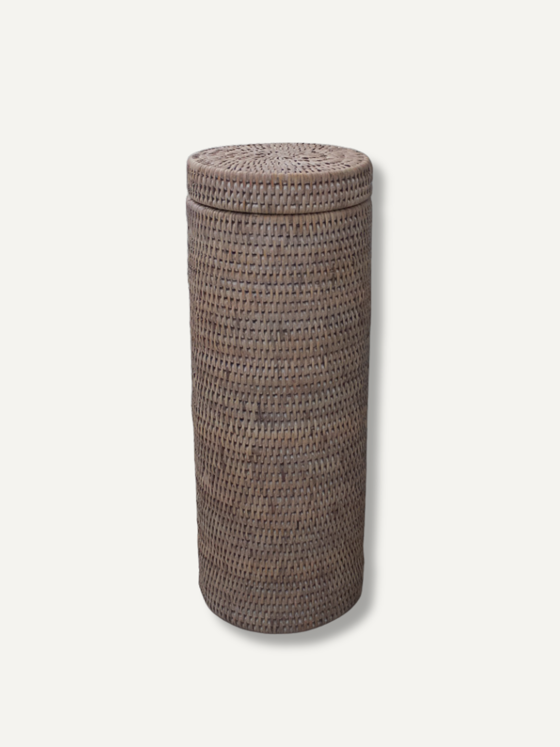 A tall, cylindrical white  white washed rattan toilet roll holder basket with a fitted lid, shown on a plain light background