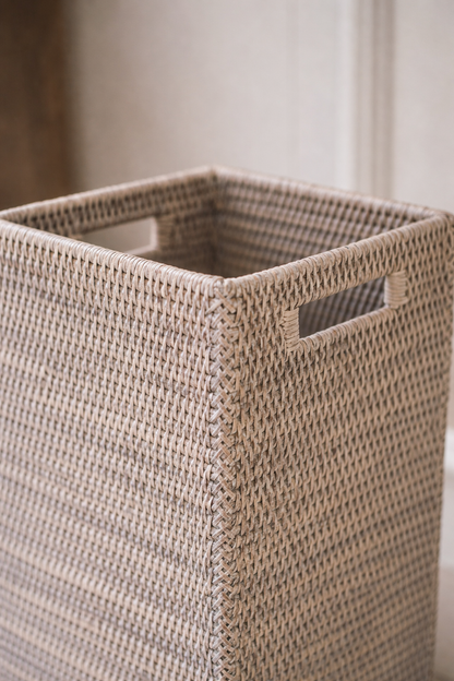 Woven umbrella basket with handles on a neutral background