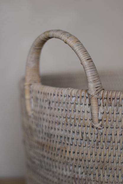 Woven basket with a handle on a neutral background