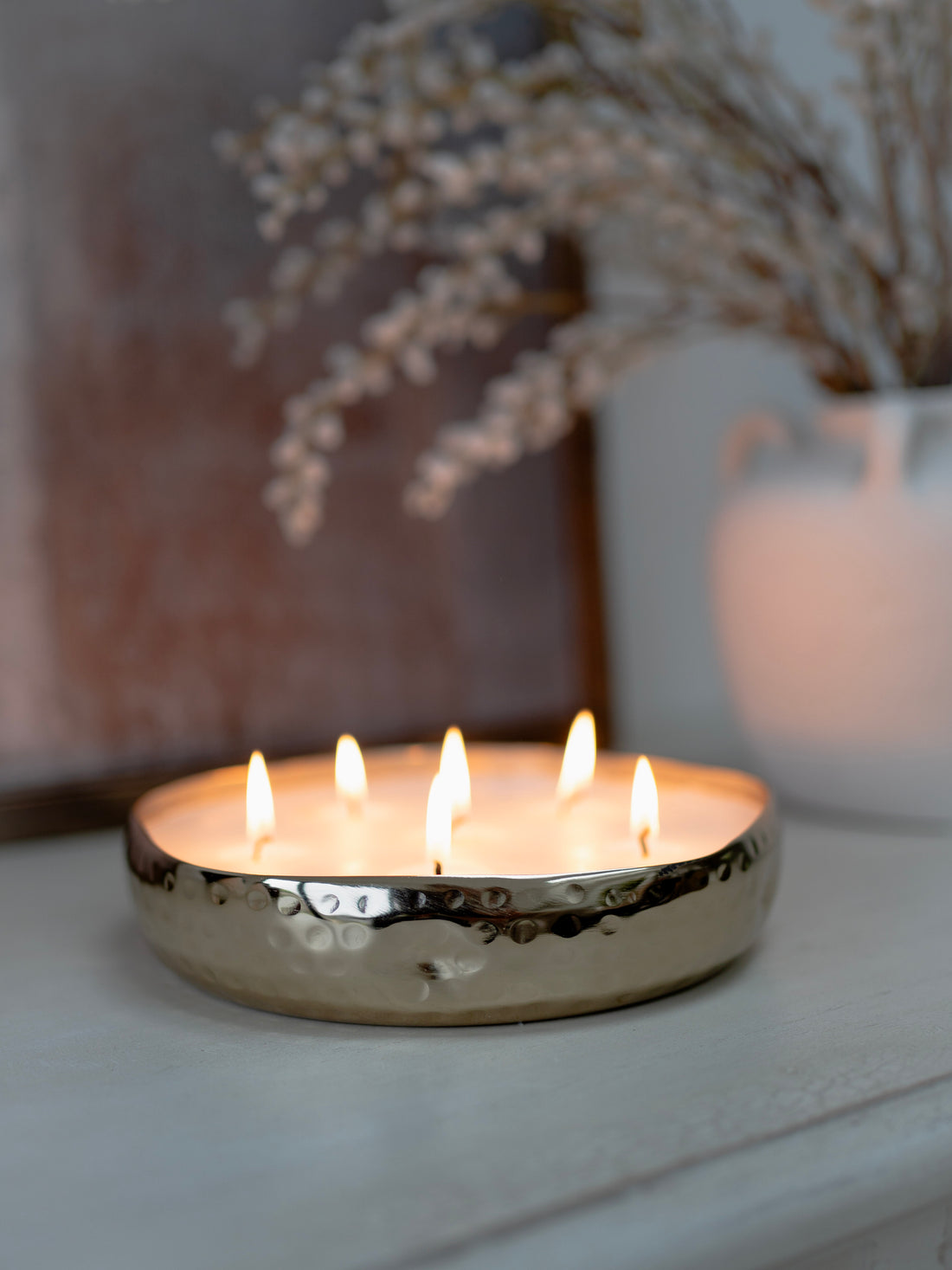 Candle in a metallic holder with a blurred background