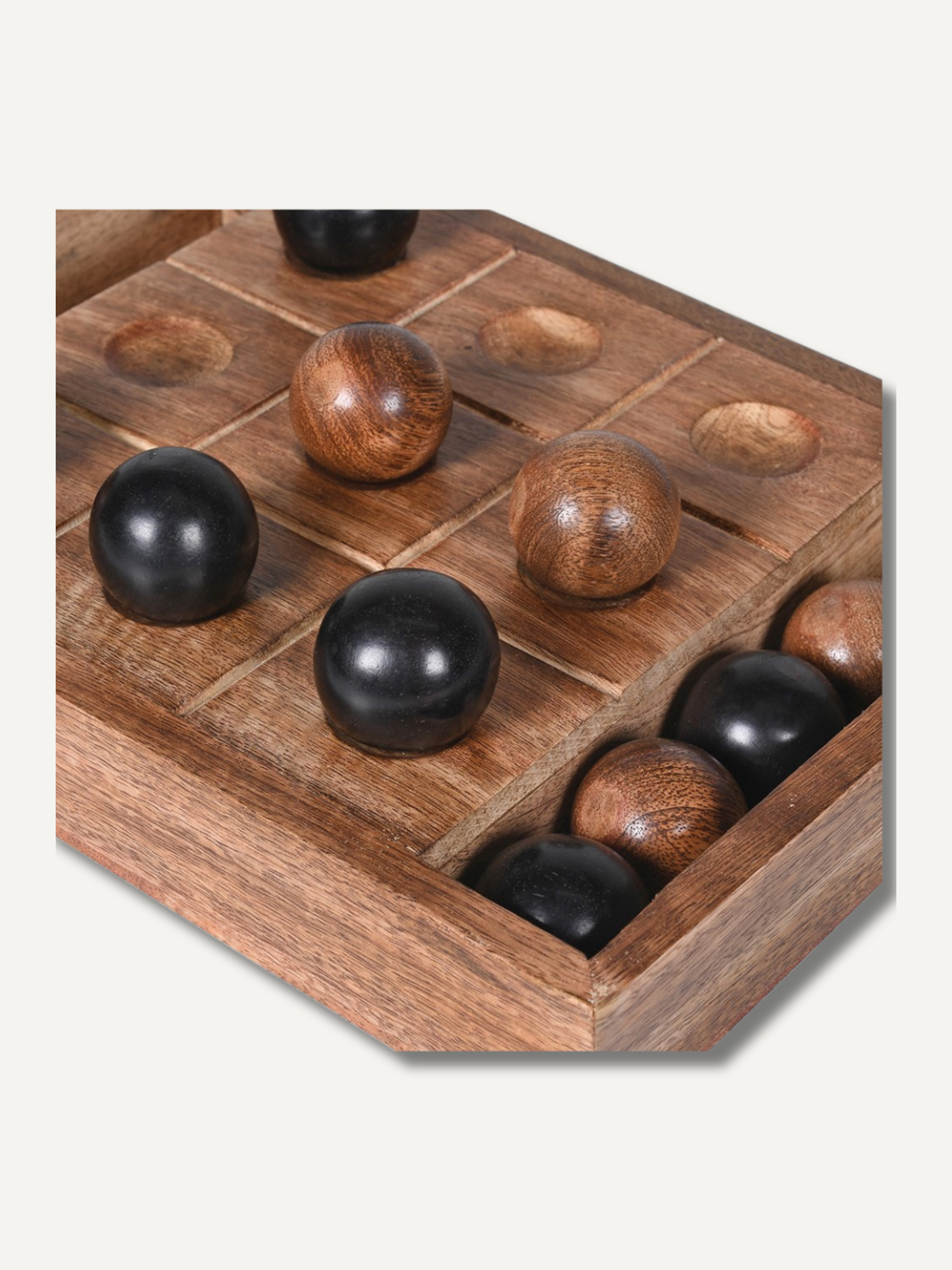 Wooden tic tac toe game board with black and brown spheres on a white background