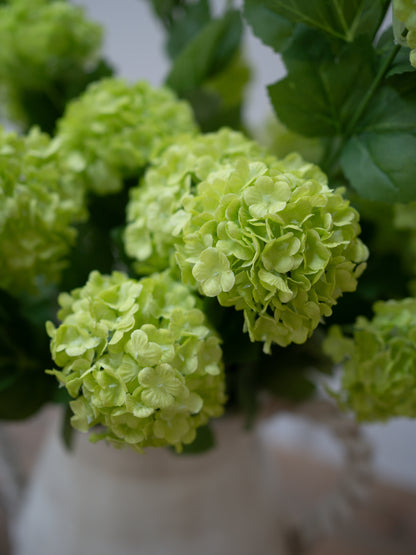 Close-up of green faux snowball flowers with a blurred background