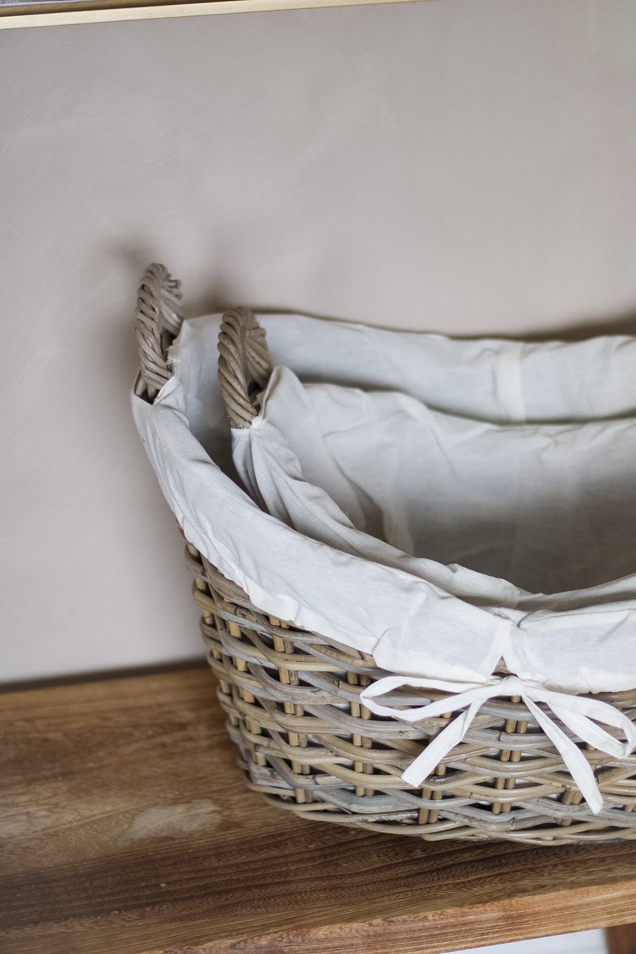 Wicker basket with white fabric lining on a wooden surface